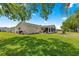 Lush backyard featuring a well-maintained lawn and screened-in porch for outdoor relaxation at 9645 Se 173Rd Pl, Summerfield, FL 34491