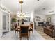 Inviting dining area showcases a chandelier, neutral paint, and an easy transition to both kitchen and living spaces at 9645 Se 173Rd Pl, Summerfield, FL 34491