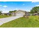 Charming single-story home with a well-manicured lawn, long driveway, and attached garage at 9645 Se 173Rd Pl, Summerfield, FL 34491