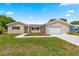 Well-kept home with lush lawn, beautiful landscaping, and an inviting driveway leading to the garage at 9645 Se 173Rd Pl, Summerfield, FL 34491