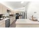Well-lit kitchen with modern stainless steel appliances and light wood cabinets at 9645 Se 173Rd Pl, Summerfield, FL 34491