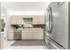 Modern kitchen with stainless steel appliances, light wood cabinets and ample counter space at 9645 Se 173Rd Pl, Summerfield, FL 34491
