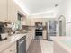 Modern kitchen with stainless steel appliances, stylish backsplash and light wood cabinetry at 9645 Se 173Rd Pl, Summerfield, FL 34491