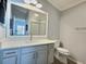 Bathroom with a white vanity, a large mirror, updated lighting, and a glass-enclosed shower at 997 Oscar Ln, The Villages, FL 32162
