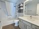 Bathroom featuring modern vanity, shower-tub combo, and handy storage baskets at 997 Oscar Ln, The Villages, FL 32162