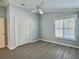 Bright bedroom with wood-look floors, ceiling fan, and ample closet space at 997 Oscar Ln, The Villages, FL 32162