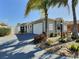 Charming single-story home with a two-car garage, desert landscaping, and a freshly painted driveway at 997 Oscar Ln, The Villages, FL 32162