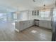 Kitchen and open living space boasts stainless appliances, quartz countertops, pendant lighting, and waterproof flooring at 997 Oscar Ln, The Villages, FL 32162