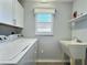 Laundry room with modern washer and dryer, utility sink and lots of light at 997 Oscar Ln, The Villages, FL 32162