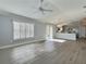 Open living space with waterproof flooring, a ceiling fan, and access to the kitchen and outdoors at 997 Oscar Ln, The Villages, FL 32162