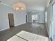 Spacious living room with a ceiling fan, waterproof floors, access to the lanai, and neutral paint at 997 Oscar Ln, The Villages, FL 32162
