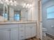 Bathroom featuring double vanity sinks, neutral countertops, and a toilet behind an open door at 1346 Kilgore Way, The Villages, FL 32163