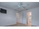 Simple, all-white bedroom with laminate flooring, and a wall-mounted television at 1346 Kilgore Way, The Villages, FL 32163