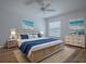Coastal-themed bedroom with woven bed frame, matching nightstands, and serene ocean artwork at 1346 Kilgore Way, The Villages, FL 32163