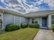 A well-maintained home exterior showcasing manicured landscaping and a welcoming front entrance under a cloudy sky at 1346 Kilgore Way, The Villages, FL 32163