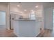 Bright kitchen with white cabinets, bar seating, and stainless appliances exudes modern charm at 1346 Kilgore Way, The Villages, FL 32163
