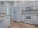 Well-lit kitchen with modern white appliances, granite counters, and ample cabinet space at 1346 Kilgore Way, The Villages, FL 32163