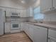 Modern kitchen equipped with white appliances, ample counter space, and plenty of cabinet storage at 1346 Kilgore Way, The Villages, FL 32163