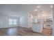 Open concept floor plan with hardwood floors connecting the living area and the kitchen with white appliances at 1346 Kilgore Way, The Villages, FL 32163
