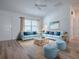 Bright living room featuring modern sofas, and an artistic beach painting, creating a relaxing ambiance at 1346 Kilgore Way, The Villages, FL 32163