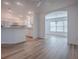 Bright open-concept layout with hardwood floors leading to a white kitchen and dining area at 1346 Kilgore Way, The Villages, FL 32163