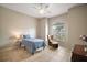 Bright bedroom features tile floors, a ceiling fan, and a comfortable chair at 10021 Lake Miona Way, Oxford, FL 34484