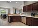Well-lit kitchen featuring stainless steel appliances, dark wood cabinets and views into the adjacent breakfast nook at 10021 Lake Miona Way, Oxford, FL 34484