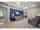 Bright living room with blue accent wall, neutral furniture, and tiled floors at 10021 Lake Miona Way, Oxford, FL 34484
