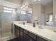 Main bathroom featuring a double sink vanity, large mirrors, and a walk-in shower at 10021 Lake Miona Way, Oxford, FL 34484