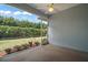Screened patio with ceiling fan overlooks a lush green lawn and trimmed hedges at 10021 Lake Miona Way, Oxford, FL 34484