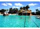 Resort-style pool with a rock waterfall, tropical landscaping, and ample seating at 10021 Lake Miona Way, Oxford, FL 34484