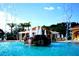 Community pool with rock features, fountains, covered seating and lounge chairs at 10021 Lake Miona Way, Oxford, FL 34484