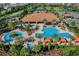 An aerial view of the community pool surrounded by palm trees and cabanas at 1047 Timbervale Trl, Clermont, FL 34715