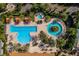 Aerial view of a luxurious community pool with cabanas and palm trees at 1047 Timbervale Trl, Clermont, FL 34715