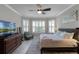 Sun-filled bedroom with a large window, a wood floor, a ceiling fan, and stylish decor at 1047 Timbervale Trl, Clermont, FL 34715