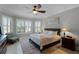 Comfortable bedroom with natural light, plantation shutters, ceiling fan, and hardwood floors at 1047 Timbervale Trl, Clermont, FL 34715