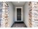Close-up of an elegant, dark-colored front door framed by stone pillars and a brick pathway leading to the entrance at 1047 Timbervale Trl, Clermont, FL 34715
