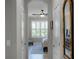 Bright hallway with hardwood floors, closet, and decorative mirror leading to bedroom with a ceiling fan and window at 1047 Timbervale Trl, Clermont, FL 34715