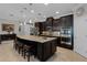 Modern kitchen featuring a central island with seating, stainless steel appliances, and dark wood cabinets at 1047 Timbervale Trl, Clermont, FL 34715