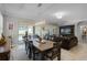 Open-concept living room with dining area, leather sofa, and entertainment center, creating an inviting and spacious atmosphere at 1047 Timbervale Trl, Clermont, FL 34715