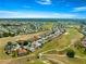 Stunning aerial view of a home nestled in a golf course community, showcasing mature trees, a lake, and picturesque streetscape at 11780 Se 178Th St, Summerfield, FL 34491