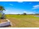 Expansive backyard view with lush green grass, a pond, and beautiful landscaping creating an inviting outdoor setting at 11780 Se 178Th St, Summerfield, FL 34491
