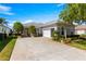 Well-maintained home exterior with a long driveway, lush landscaping, and a two-car garage at 11780 Se 178Th St, Summerfield, FL 34491