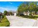Attractive single-Gathering home featuring a well-maintained lawn, mature trees, and an expansive driveway with attached two car garage at 11780 Se 178Th St, Summerfield, FL 34491