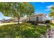 Charming home with lush green lawn, mature tree, and well-maintained landscaping offers a welcoming curb appeal at 11780 Se 178Th St, Summerfield, FL 34491