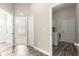 A neutral-toned hallway with gray wood floors leads to a bathroom, bedroom, and laundry area at 11780 Se 178Th St, Summerfield, FL 34491