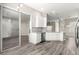 Kitchen displays stainless appliances, granite counters, white cabinets, and gray wood floors at 11780 Se 178Th St, Summerfield, FL 34491