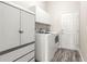 Laundry room with gray wood-look flooring and white washer and dryer at 11780 Se 178Th St, Summerfield, FL 34491