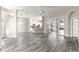 Open floor plan featuring gray wood-look floors and access to the kitchen and lanai at 11780 Se 178Th St, Summerfield, FL 34491
