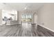 Open living area with gray wood-look floors leading to a lanai and views of the backyard at 11780 Se 178Th St, Summerfield, FL 34491